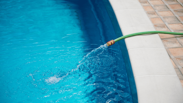 pool dilution, drain pool, refill pool, pool hose, chemical accumulation in pools, orenda, shutterstock - Edited