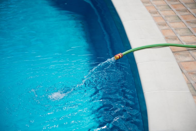 pool dilution, drain pool, refill pool, pool hose, chemical accumulation in pools, orenda, shutterstock